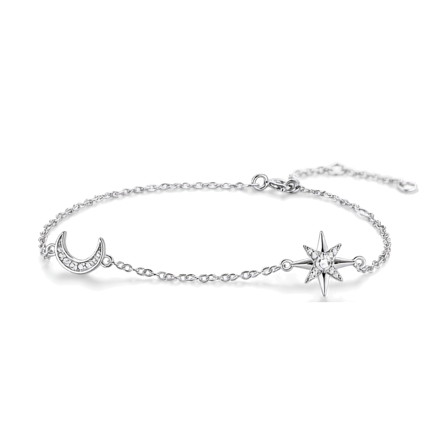 A delicate silver chain bracelet featuring a crescent moon charm and a starburst charm, both adorned with small clear stones, set against a plain white background.