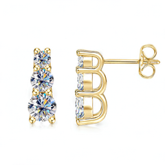 A pair of yellow gold stud earrings featuring three round-cut clear gemstones in a vertical setting, shown from both the front and side angles on a white background.