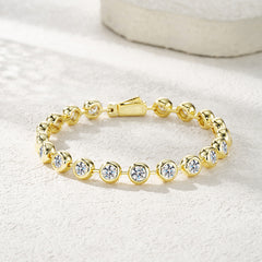 Gold bracelet with clear stones on a light background