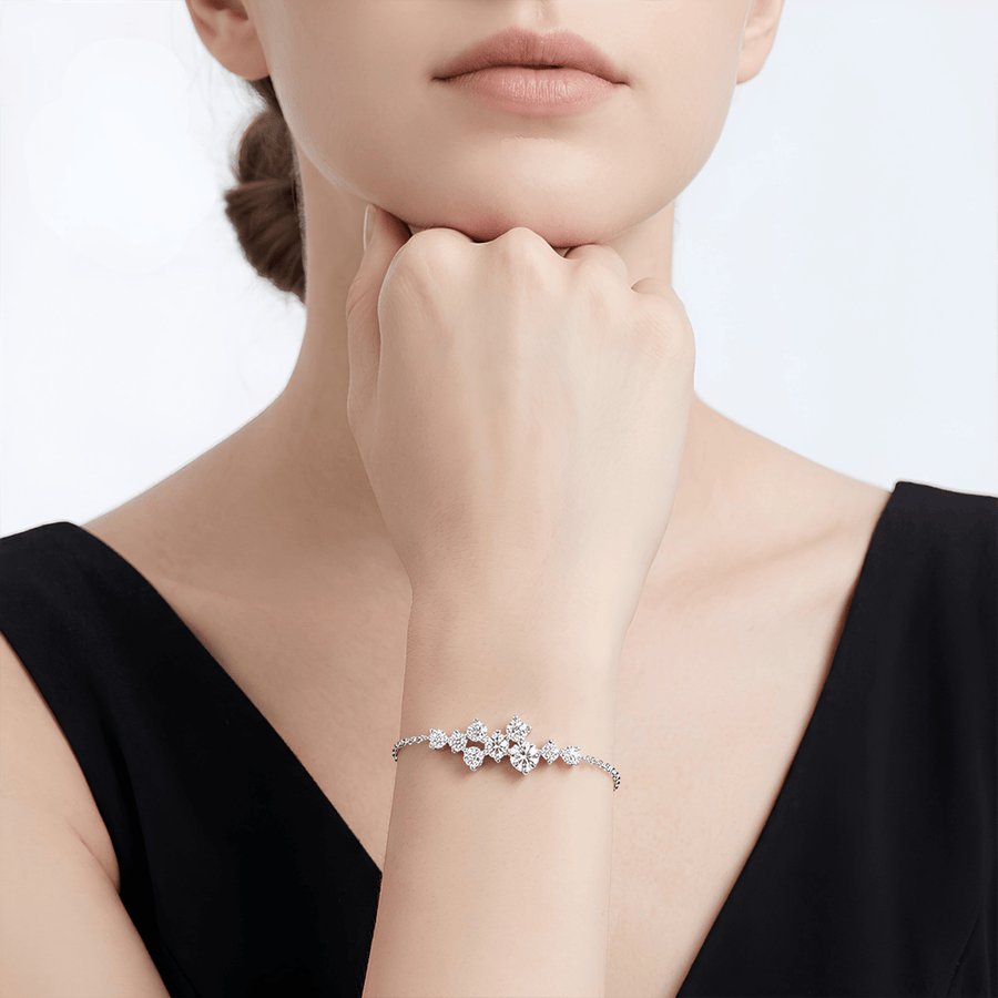 A delicate silver chain bracelet featuring a central cluster of clear, sparkling gemstones in a floral or leaf-like arrangement, displayed on a clean white background.
