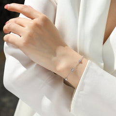 Silver bracelet on a person's wrist with a blurred white background