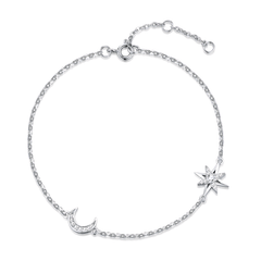 A delicate silver chain anklet featuring a crescent moon and starburst charm, embellished with small clear crystals, shown on a plain white background.