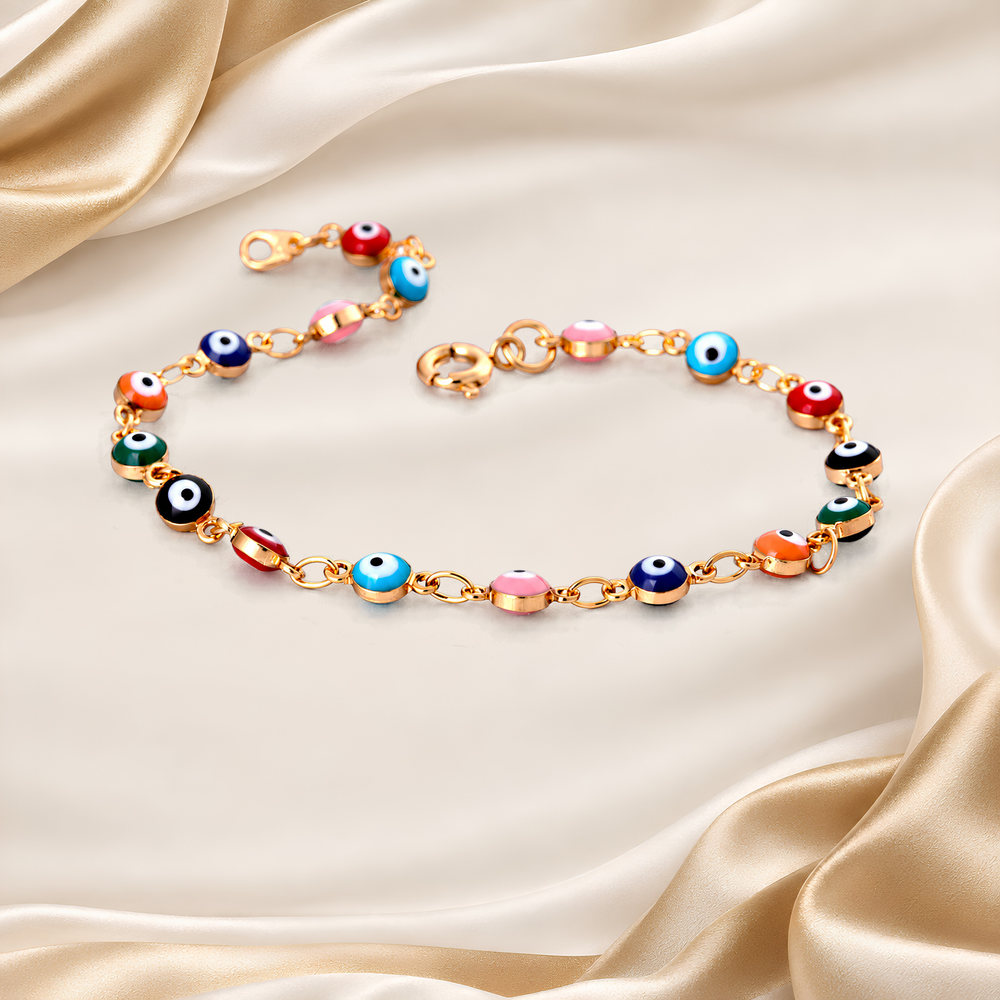 A gold-tone chain bracelet decorated with colorful evil eye beads, arranged in a circle on a draped beige satin fabric background.