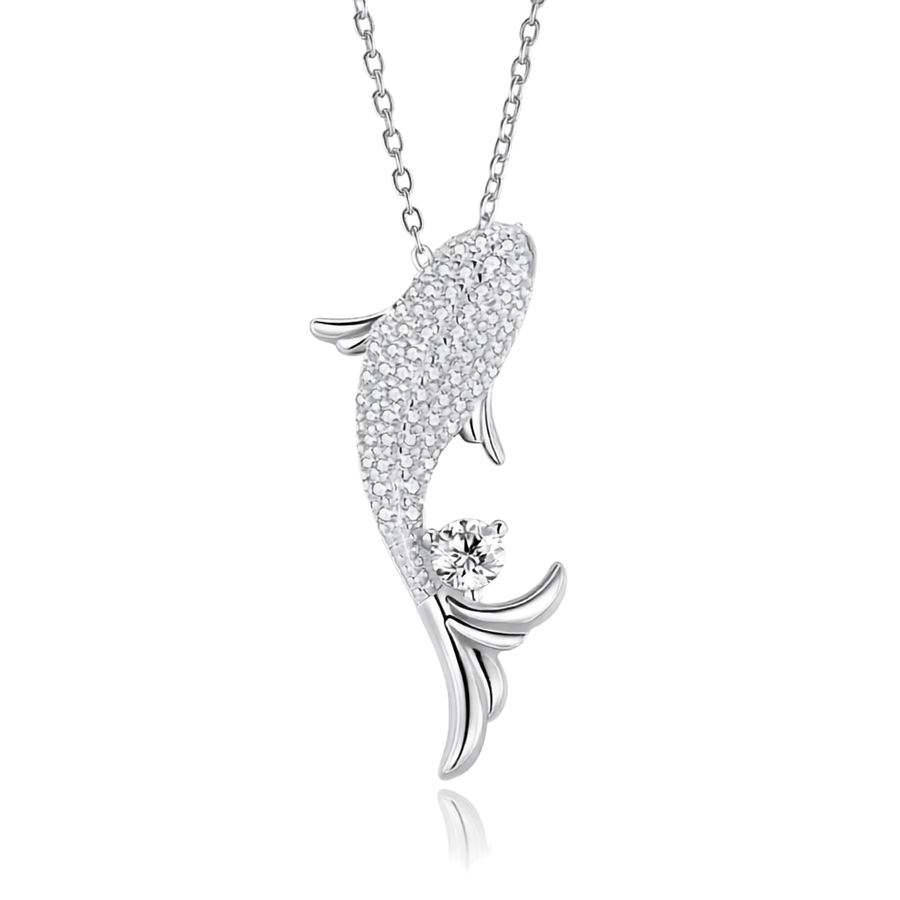 A silver-toned fish pendant necklace paved with small clear stones, with a single round clear gemstone near the tail, shown on a white background with a faint reflection below.