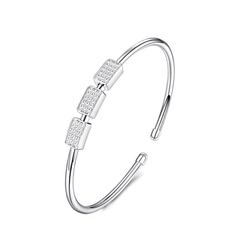 A silver-toned open cuff bangle bracelet with three rectangular bezel-set clear stones on the front, shown on a plain white background.