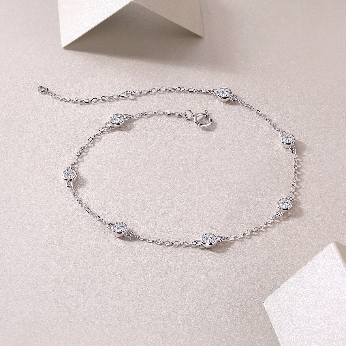 Silver bracelet with gemstones on a light beige background