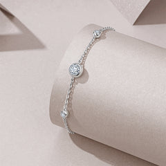 Silver bracelet with a diamond on a beige surface