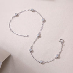 Silver bracelet with diamond-like beads on a light pink background