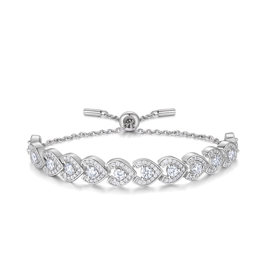 A silver tennis bracelet featuring heart-shaped pavé settings with clear round and pear-cut gemstones, shown on a clean white background.