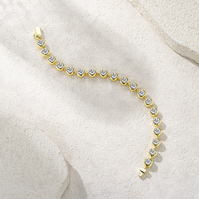 Gold bracelet with clear stones on a light beige background