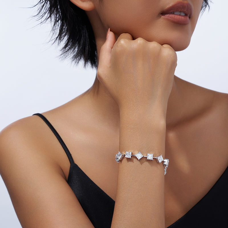 Woman wearing a diamond bracelet on a plain background